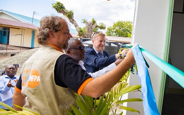 Mr. Mark Bryan Schreiner, Prof. Jamal Katundu and Mr. Holger Tausch cut the ribbon to mark the official handover.