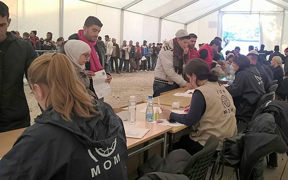 Migrantinnen und Migranten warten darauf, offiziell registriert zu werden.