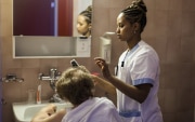 Die junge Eritreerin Samrawit wurde an ihrem Arbeitsort, einem Altersheim im Kanton Wallis, fotografiert. Sie kämmt die Haare einer alten Frau.