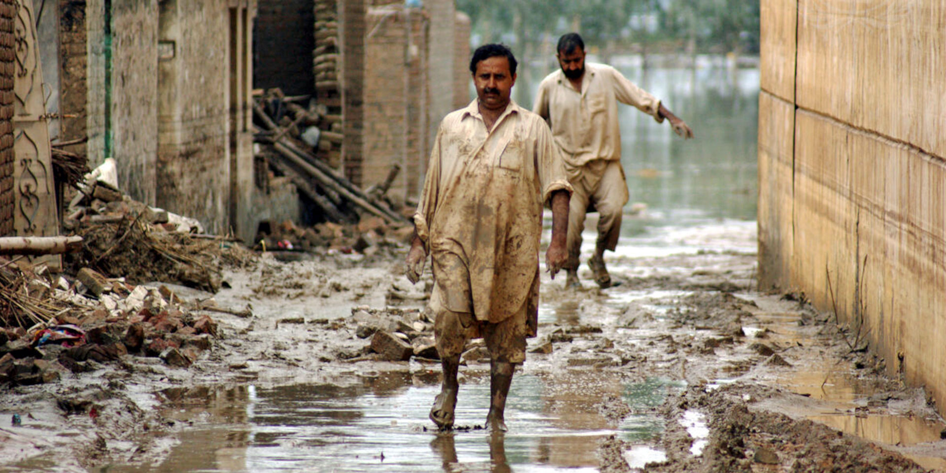 Victims of the floods of 2010 in Pakistan walk through water-filled streets in the northwestern city of Nowshera.