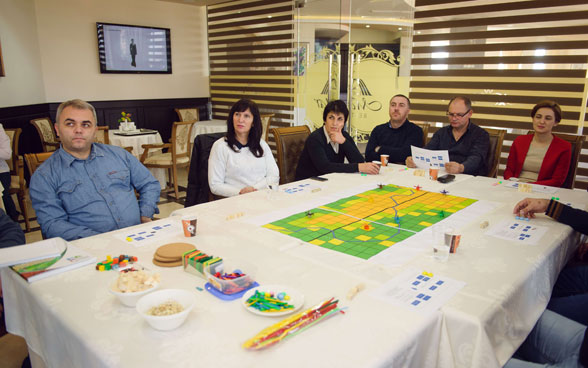 Participantes de un taller de partes interesadas reunidos en torno a una mesa.
