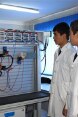Un insegnante e tre apprendisti davanti a un quadro elettrico
