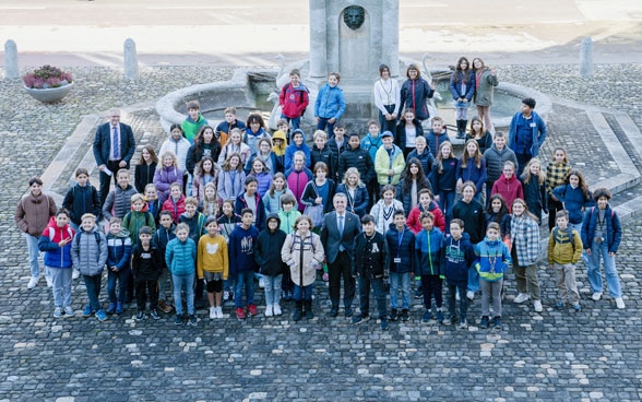 President Ignazio Cassis poses with the 80 children in front of the Federal Palace.