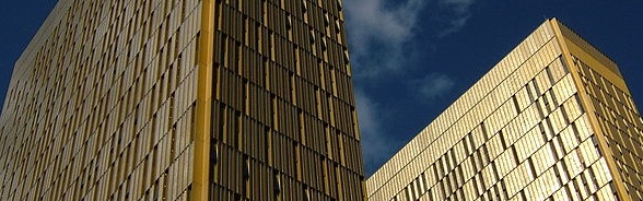 Die hohen Türme des Europäischen Gerichtshofs in Luxemburg glänzen goldfarben vor blauem Himmel.