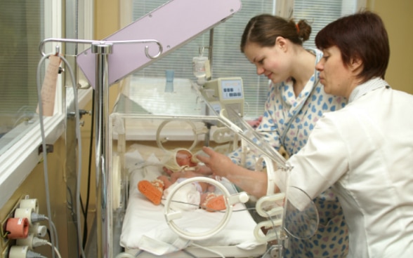 Una dottoressa con madre e neonato